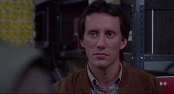 Movie still from “Videodrome” (1983), directed by David Cronenberg – A person wearing a brown jacket; Close Up shot, Low angle