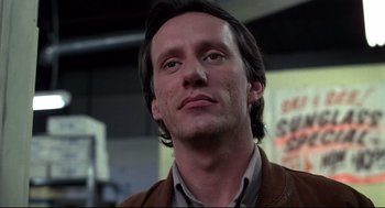 Movie still from “Videodrome” (1983), directed by David Cronenberg – A person wearing a brown jacket; Close Up shot, Low angle