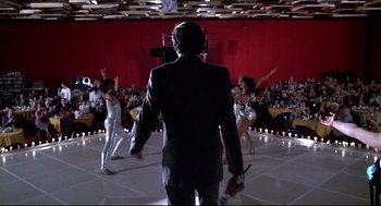 Movie still from “Videodrome” (1983), directed by David Cronenberg – A group of people dancing in a room with red walls; Wide shot, Low angle