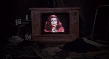 Movie still from “Videodrome” (1983), directed by David Cronenberg – An old tv with a picture of a woman on the screen; Medium shot, High angle