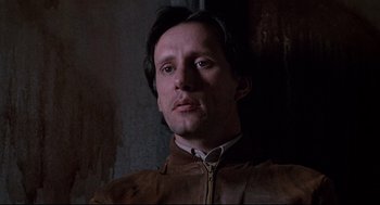 Movie still from “Videodrome” (1983), directed by David Cronenberg – A person wearing a brown jacket; Close Up shot, Low angle