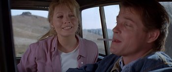 Movie still from “Village of the Damned” (1995), directed by John Carpenter – A woman sitting next to another woman in a car; Close Up shot, Over the shoulder angle