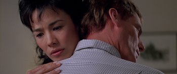 Movie still from “Village of the Damned” (1995), directed by John Carpenter – A man and a woman embracing each other; Close Up shot, Over the shoulder angle