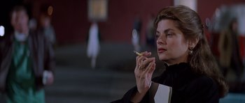 Movie still from “Village of the Damned” (1995), directed by John Carpenter – A woman is holding a cigarette in her hand; Close Up shot, Low angle