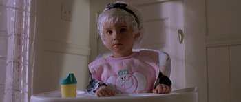 Movie still from “Village of the Damned” (1995), directed by John Carpenter – A little girl sitting in a high chair; Close Up shot, High angle