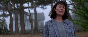 Movie still from “Village of the Damned” (1995), directed by John Carpenter – A woman standing in front of a house in the fog; Close Up shot, Low angle
