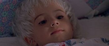 Movie still from “Village of the Damned” (1995), directed by John Carpenter – A child's face in a blanket; Close Up shot, High angle