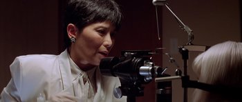 Movie still from “Village of the Damned” (1995), directed by John Carpenter – A woman looking into a video camera; Close Up shot, Low angle