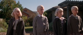 Movie still from “Village of the Damned” (1995), directed by John Carpenter – Two children in costumes standing in front of a house; Medium shot, Low angle