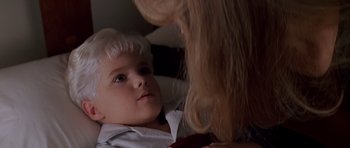 Movie still from “Village of the Damned” (1995), directed by John Carpenter – A young boy looking at a blond haired woman; Close Up shot, High angle