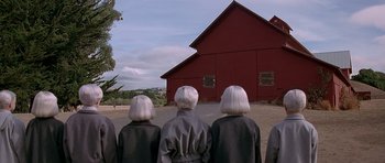 Movie still from “Village of the Damned” (1995), directed by John Carpenter – A group of people standing in front of a red barn; Wide shot, Low angle