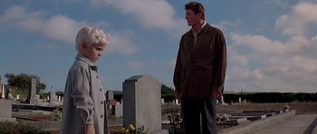 Movie still from “Village of the Damned” (1995), directed by John Carpenter – A man and a boy in a cemetery; Medium shot, Low angle