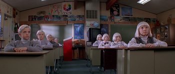 Movie still from “Village of the Damned” (1995), directed by John Carpenter – A group of children sitting at desks in a classroom; Wide shot, High angle
