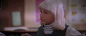 Movie still from “Village of the Damned” (1995), directed by John Carpenter – A little girl with white hair and a white wig; Close Up shot, High angle