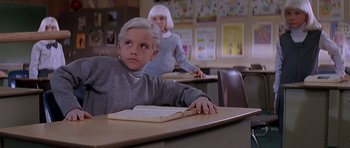 Movie still from “Village of the Damned” (1995), directed by John Carpenter – A boy and a girl sitting at a table in a classroom; Close Up shot, High angle
