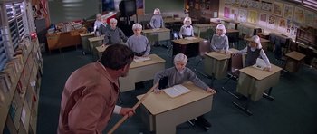 Movie still from “Village of the Damned” (1995), directed by John Carpenter – A group of people sitting at desks in a classroom; Wide shot, High angle