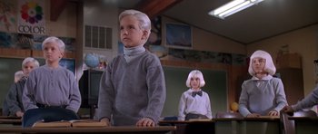 Movie still from “Village of the Damned” (1995), directed by John Carpenter – A boy and a girl are standing in a classroom; Medium shot, Low angle