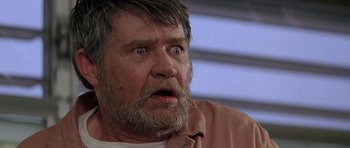 Movie still from “Village of the Damned” (1995), directed by John Carpenter – An old man with a beard and a surprised look on his face; Close Up shot, Low angle