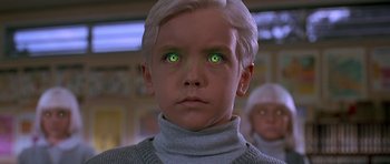 Movie still from “Village of the Damned” (1995), directed by John Carpenter – A young boy with green eyes stares into the distance; Close Up shot, Low angle