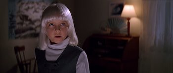 Movie still from “Village of the Damned” (1995), directed by John Carpenter – A young girl with blonde hair wearing a white wig; Close Up shot, Low angle