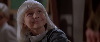 Movie still from “Village of the Damned” (1995), directed by John Carpenter – A woman with white hair is looking upward; Close Up shot, Low angle