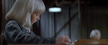 Movie still from “Village of the Damned” (1995), directed by John Carpenter – A young girl with white hair using a computer keyboard; Close Up shot, Low angle