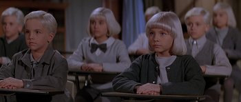 Movie still from “Village of the Damned” (1995), directed by John Carpenter – Two young girls sitting at a desk in a classroom; Close Up shot, High angle