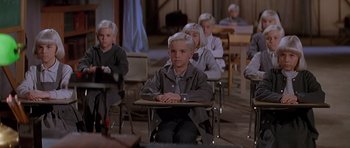 Movie still from “Village of the Damned” (1995), directed by John Carpenter – A group of children sitting at a desk in a classroom; Medium shot, High angle