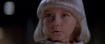 Movie still from “Village of the Damned” (1995), directed by John Carpenter – A child with a white wig; Close Up shot, High angle