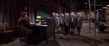Movie still from “Village of the Damned” (1995), directed by John Carpenter – A group of people in a room with a computer; Wide shot, High angle