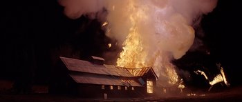 Movie still from “Village of the Damned” (1995), directed by John Carpenter – A large fire burning in the sky next to a building; Extreme Wide shot, Low angle