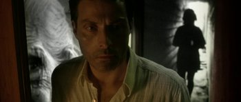 Movie still from “Vinyan” (2008), directed by Fabrice du Welz – A person wearing a white shirt; Close Up shot, Low angle