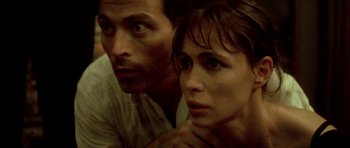 Movie still from “Vinyan” (2008), directed by Fabrice du Welz – A man and a woman are looking at the camera; Close Up shot, High angle