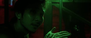 Movie still from “Vinyan” (2008), directed by Fabrice du Welz – A man with a finger up to his face; Close Up shot, Overhead angle