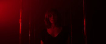 Movie still from “Vinyan” (2008), directed by Fabrice du Welz – A woman in black shirt standing next to a wall; Medium shot, Low angle