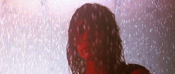 Movie still from “Vinyan” (2008), directed by Fabrice du Welz – A woman standing in the rain with her eyes closed; Close Up shot, Low angle