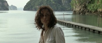 Movie still from “Vinyan” (2008), directed by Fabrice du Welz – A woman standing in front of a body of water; Close Up shot, Low angle