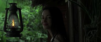 Movie still from “Vinyan” (2008), directed by Fabrice du Welz – A beautiful woman standing in front of a tree; Close Up shot, Over the shoulder angle