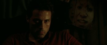 Movie still from “Vinyan” (2008), directed by Fabrice du Welz – A person in a dark room; Close Up shot, Low angle