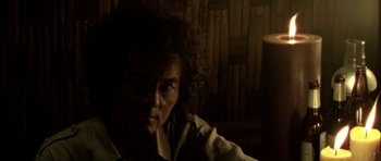 Movie still from “Vinyan” (2008), directed by Fabrice du Welz – A man with a curly hair and glasses is looking at the camera; Close Up shot, Low angle