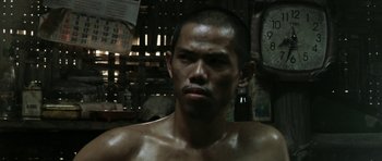 Movie still from “Vinyan” (2008), directed by Fabrice du Welz – A man with no shirt is looking at the camera; Close Up shot, Low angle