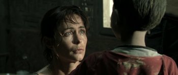 Movie still from “Vinyan” (2008), directed by Fabrice du Welz – A person with a crying face; Close Up shot, Over the shoulder angle