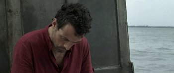 Movie still from “Vinyan” (2008), directed by Fabrice du Welz – A person wearing a red shirt; Close Up shot, High angle