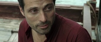 Movie still from “Vinyan” (2008), directed by Fabrice du Welz – A person wearing a red shirt; Close Up shot, Over the shoulder angle