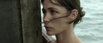 Movie still from “Vinyan” (2008), directed by Fabrice du Welz – A person near a tree; Close Up shot, Low angle