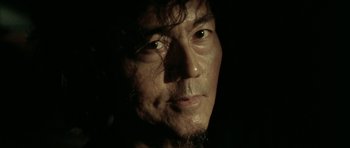 Movie still from “Vinyan” (2008), directed by Fabrice du Welz – A man's face in the dark; Extreme Close Up shot, Low angle