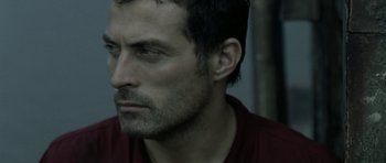 Movie still from “Vinyan” (2008), directed by Fabrice du Welz – A person wearing a red shirt; Close Up shot, Low angle