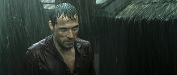 Movie still from “Vinyan” (2008), directed by Fabrice du Welz – A man with wet hair standing in the rain; Close Up shot, Low angle