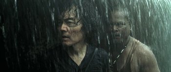 Movie still from “Vinyan” (2008), directed by Fabrice du Welz – A man and a woman in the rain; Close Up shot, Low angle