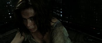 Movie still from “Vinyan” (2008), directed by Fabrice du Welz – A woman with long dark hair is looking at the camera; Close Up shot, High angle